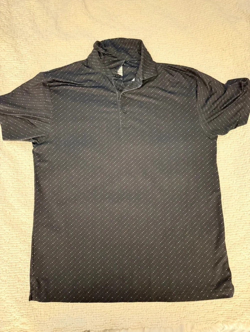 Callaway Opti-Dri golf polo in black with a clean white dash pattern.